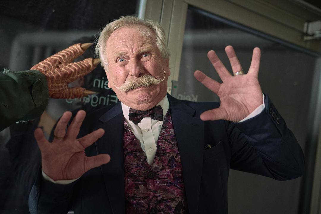 Schuldirektor Udo Brückmann (Henning Krautmacher) wird von einem Dinosaurier bedroht