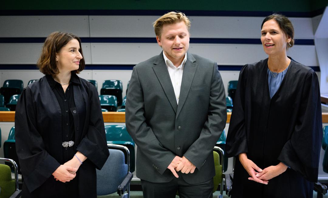 Satiriker Sebastian Hotz alias El Hotzo steht zusammen mit seinen Rechtsanwältinnen Kerstin Schmitt (l.) und Carolin Lütcke (r.) im Amtsgericht Tiergarten