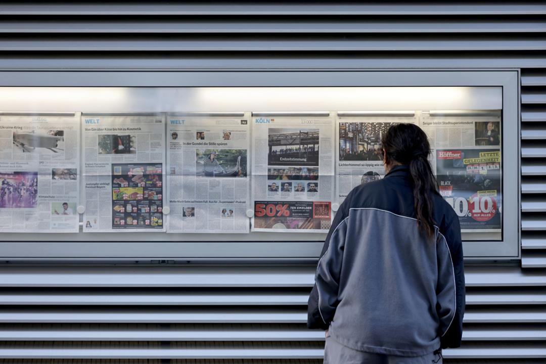 Tageszeitungsseiten in einem Aushangkasten
