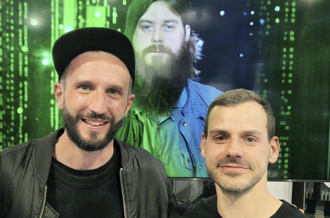 Die Regisseure Benjamin Rost (links) und Erec Brehmer vor einem Porträt von Michael Born