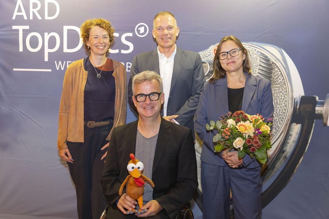 Dioe Autoren Ariane Riecker, Olaf Jacobs, ARD-Chefredakteur Oliver Köhr und MDR-Redakteurin Anais Roth (von links) mit dem Moorhuhn bei der Preisverleihung